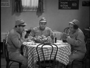 Moe, Curly and Larry dressed as Japanese soldiers eat lunch at a diner in No Dough Boys